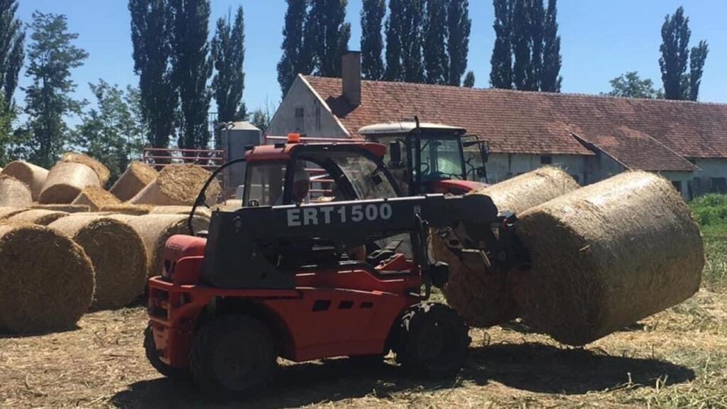 Utovarivač sa priključkom zarolobale na gradilištu.